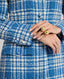 Model wearing The Lady Check Wool Coat in Butterfly Blue—a tailored, heritage-style coat, showcasing the buttoned sleeve detail.