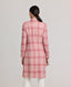 Model wearing The Lady Check Wool Coat in pink—a single-breasted, tailored coat featuring a pink and cream check pattern, functional flap pockets, and fabric-covered buttons, exuding practical femininity and quintessential elegance. Back view.