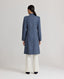 Model wearing the Louise Herringbone Funnel Wool Coat in blue—a sophisticated outerwear piece featuring classic tailoring with a contemporary twist. Back view.