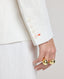 Close-up of model wearing the Elizabeth Linen Jacket in White, featuring white buttons and the contrast orange buttonhole on cuff.