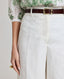 Close-up of model wearing the relaxed fit Elizabeth Linen Trousers in White, highlighting its front pleat detail.