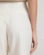 Close-up of back view of model wearing the Corine Tailored Stripe Shorts in Taupe showing details of the welt back pockets.