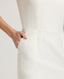Close-up of model wearing the Meryl Shift Dress in White - highlighting its side pockets.