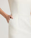 Close-up of model wearing the Meryl Shift Dress in White - highlighting its side pockets.