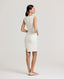 Back view of a model wearing the Meryl Shift Dress in White - a fitted mini dress with a clean neckline, invisible zip and princess seams.