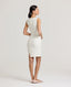 Back view of a model wearing the Meryl Shift Dress in White - a fitted mini dress with a clean neckline, invisible zip and princess seams.