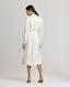 Back view of model wearing the Meryl Shirt Dress In White. Midi length utility dress with patch pockets.