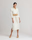Model wearing the Meryl Shirt Dress In White. Midi length utility dress with patch pockets. Dress is worn with the nude Cummerbund Belt.