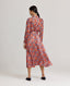 Model wearing the Sidney Shirt Dress in Liberty silk-satin—a slip midi dress with long sleeves and a relaxed fit, elegantly designed to enhance movement and create a fluid silhouette, perfect for a ladies' lunch or a summer soirée. Back view.