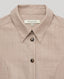 Detail of pointed collar and tortoiseshell buttons of the Diane utility shirt dress in taupe.