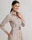 A model wearing the Diane Wool Shirt Dress in Taupe, a mid-length utility dress crafted from 100% pure new wool. This elegant yet practical piece offers a luxurious blend of comfort and style, making it perfect for transitioning from day to night. Side view.