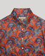 Collar and button details of the Sidney Paisley Liberty Silk Shirt in fiery orange-red—a 100% silk satin shirt featuring a paisley pattern, designed to elevate both country and city looks. Pair it with tailored trousers for a refined, office-ready ensemble, or dress down with jeans for a relaxed look. Front view.