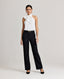 A model wearing the Zoe Tie Neck Silk Blouse in Ice White, crafted from a delicate silk blend with an elegant tie-neck detail. Front view paired with the Jessica black trouser and black belt.