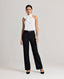 A model wearing the Zoe Tie Neck Silk Blouse in Ice White, crafted from a delicate silk blend with an elegant tie-neck detail. Front view paired with the Jessica black trouser and black belt.