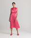 Front view of model wearing Celeste Liberty Silk Dress In Coral, featuring a high neck sleeveless dress with tie and pleat detailing at the front.