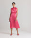 Front view of model wearing Celeste Liberty Silk Dress In Coral, featuring a high neck sleeveless dress with tie and pleat detailing at the front.