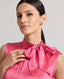 Close-up front view of model wearing Celeste Liberty Silk Dress In Coral, showcasing the high neck and tie neck details.