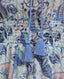 Detail of the cord tassel and the shirred waist of the Sophia Liberty Silk Tiered Dress In Blue.