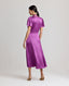Back view of model wearing the Nicole Liberty Silk Tie Neck Dress In Amethyst with detachable neck tie.