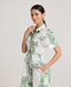 Close-up of model wearing the Ella Shirt Dress in Tropical Green. This dress has folded cap sleeves, concealed placket with mother of pearl buttons, hidden pockets at the side seams and comes with a tubular belt.