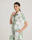 Close-up of model wearing the Ella Shirt Dress in Tropical Green. This dress has folded cap sleeves, concealed placket with mother of pearl buttons, hidden pockets at the side seams and comes with a tubular belt.