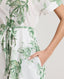 Close-up of model wearing the Ella Shirt Dress in Tropical Green, featuring the tubular belt in the same fabric, concealed placket with mother of pearl buttons and hidden pockets at side seams.