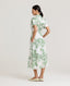 Back view of model wearing the Ella Shirt Dress in Tropical Green. This dress has folded cap sleeves, concealed placket with mother of pearl buttons, hidden pockets at the side seams and comes with a tubular belt.