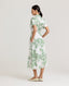 Back view of model wearing the Ella Shirt Dress in Tropical Green. This dress has folded cap sleeves, concealed placket with mother of pearl buttons, hidden pockets at the side seams and comes with a tubular belt.