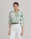 Model wearing the Flora Blouse In Tropical Green, featuring a dropped shoulder, puffed 3/4 length sleeves, gathered above the elbow, narrow cuffs and covered buttons.