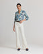 Full view of model wearing the Ivy Silk Cotton Blouse In Navy Floral, styled with Really Wild's brown leather belt and Meryl Slim Straight Fitted Trousers.