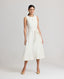 Model wearing the Meryl Fitted Skater Dress In White. This dress features a full skirt and a 5cm wide belt, stab stitching detail, mother of pearl button and rouleaux loop fastening with invisible zip.