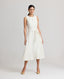 Model wearing the Meryl Fitted Skater Dress In White. This dress features a full skirt and a 5cm wide belt, stab stitching detail, mother of pearl button and rouleaux loop fastening with invisible zip.