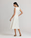 Back view of model wearing the Meryl Fitted Skater Dress In White. This dress features a full skirt and a 5cm wide belt, stab stitching detail, mother of pearl button and rouleaux loop fastening with invisible zip.