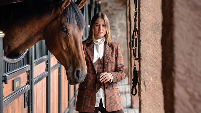 Girl in Tweed Blazer and Waistcoat by horse in stables