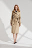 Woman wearing a beige trench coat on a white background