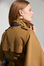 Woman wearing a brown coat against a plain background