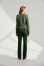 Back of model wearing a green boucle jacket and green pants on a white background