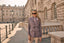 Woman in a purple safari jacket standing in front of a historic building