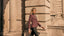 Model in purple blazer walking outside a historic building 