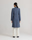 Model wearing the Louise Herringbone Funnel Wool Coat in blue—a sophisticated outerwear piece featuring classic tailoring with a contemporary twist. Back view.