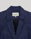 Notched lapel detail of the Olivia Wool Linen Tie Belted Jacket In Denim.