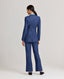 Model wearing the Olivia Wool Linen Tie Belted Jacket in denimâ€”a fitted jacket crafted from a luxurious wool-linen blend, featuring a tie belt and denim-like appearance, perfect for pairing with jeans or the Olivia Slim Straight trousers as shown. Back view.