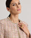 Model wearing the Cece Bouclé Jacket in rose check—a modern, feminine take on a classic suit jacket, crafted from a luxurious linen blend in an elegant rose check pattern. This cropped jacket features frayed edges and a hook-and-eye closure, making it the perfect accompaniment with both jeans and a tee, or teamed with the matching skirt.  Close up side view.