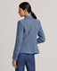 Model wearing the Elinor Short Tweed Jacket in indigo denim bouclé—a short tailored jacket cut to showcase a refined silhouette, perfect for layering through the seasons. Back view of the jacket.