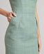 Model wearing the Jackie Wool Silk Shift Dress in sea green—a stand-out dress crafted from a blend of the finest wool, silk, and linen, featuring a simple structure and bold sea green colour. Detailed view of the pocket.