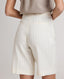 Back view of model wearing the Corine Tailored Stripe Shorts in Taupe.
