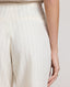 Close-up of back view of model wearing the Corine Tailored Stripe Shorts in Taupe showing details of the welt back pockets.