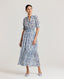 Model wearing the Sophia Liberty Silk Tiered Dress In Blue. This maxi dress has a cord tassel detail at the neck, shirred waist and cuffs and a stand up collar.