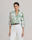 Model wearing the Flora Blouse In Tropical Green, featuring a dropped shoulder, puffed 3/4 length sleeves, gathered above the elbow, narrow cuffs and covered buttons. 