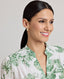 Close-up of model wearing the Flora Blouse In Tropical Green, featuring the dropped shoulder, collar and neckline. 